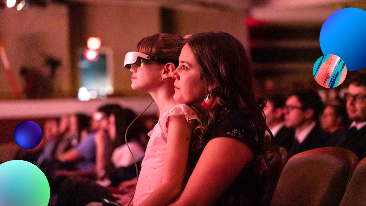 A person with their child wearing a VR headset watching a live performance