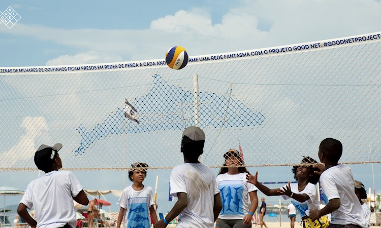 Children playing volleyball with a Good Net project net