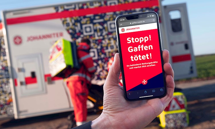 A warning sign on a smartphone warning the user to stop gawking when pointed at the QR code on an ambulance