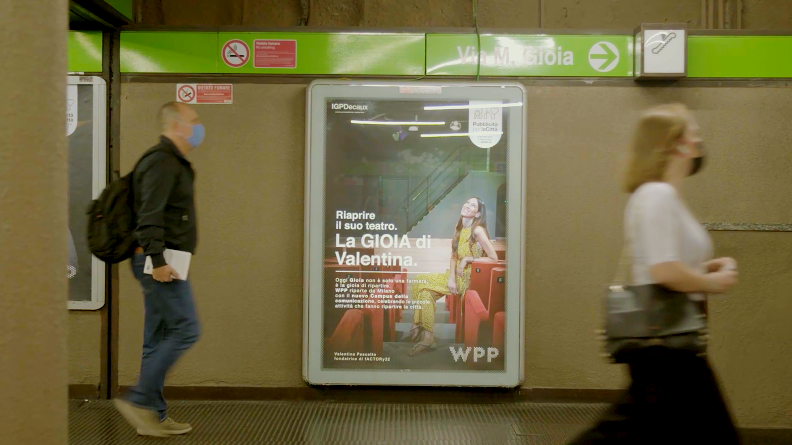 People walking past a poster for WPP's Gioia campaign in a busy metro station