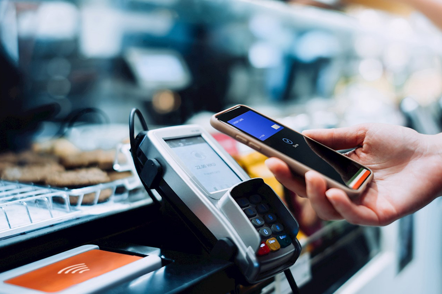Person holding phone over payment machine