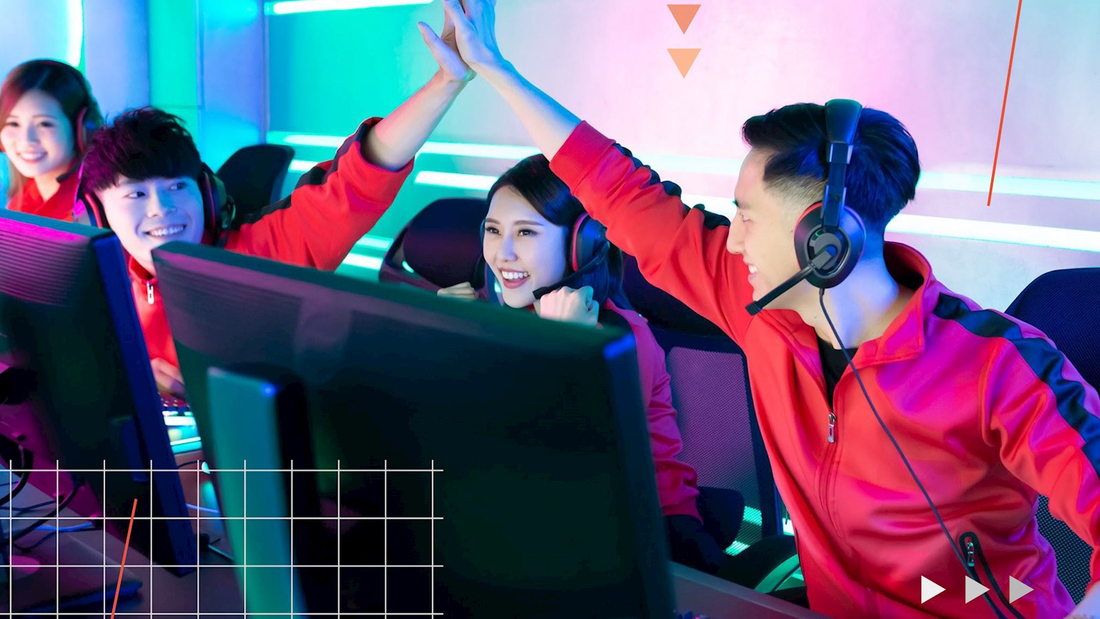 People sitting in front of computers playing games and high-fiving