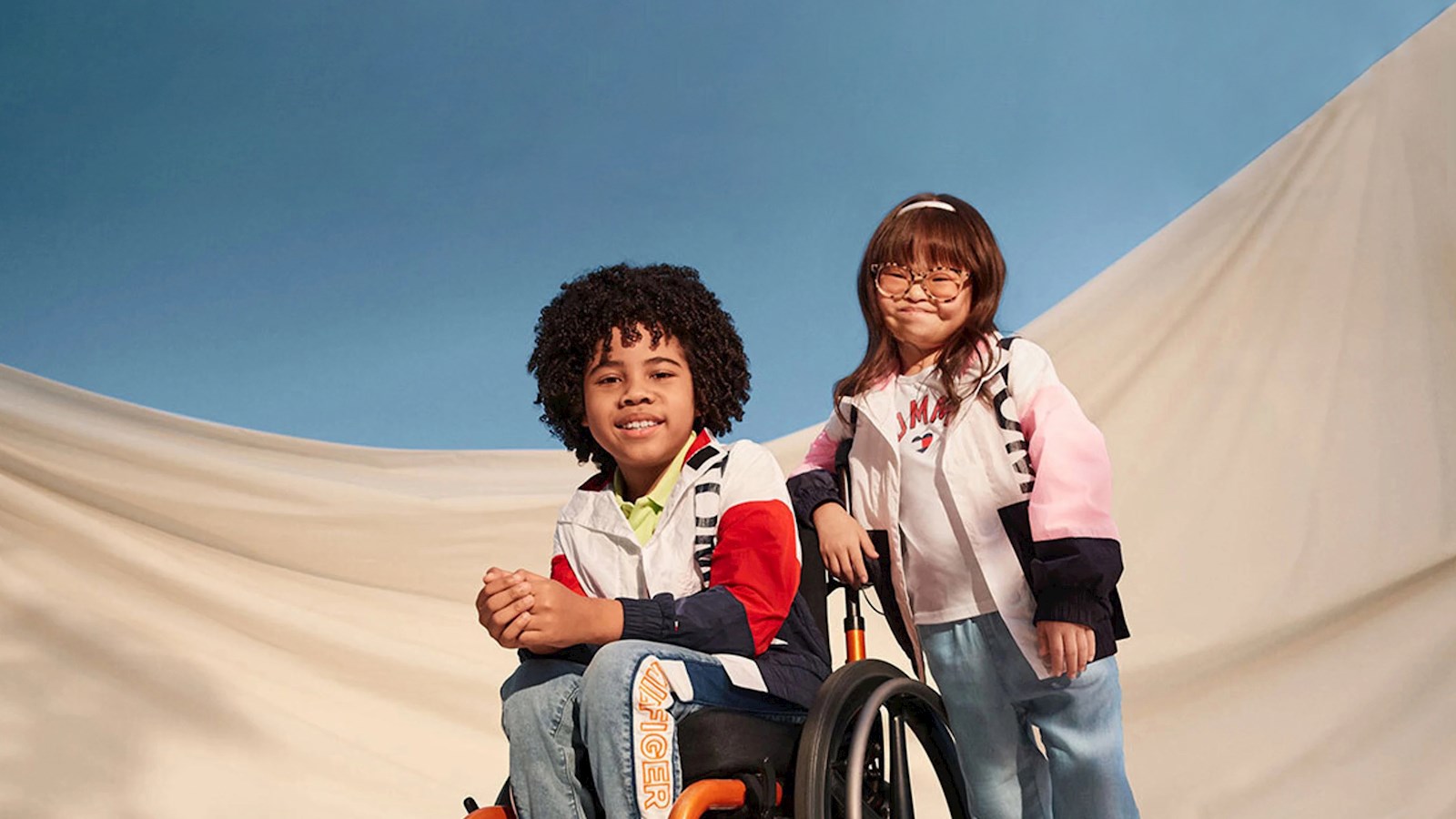 Girl and boy in a wheelchair on blue and white background