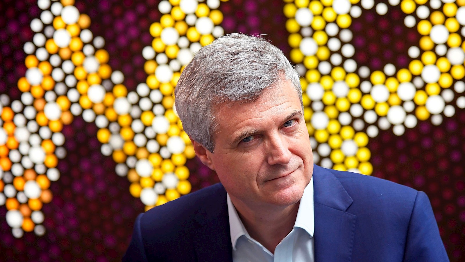 Mark Read looking towards the camera with a large WPP logo in the background