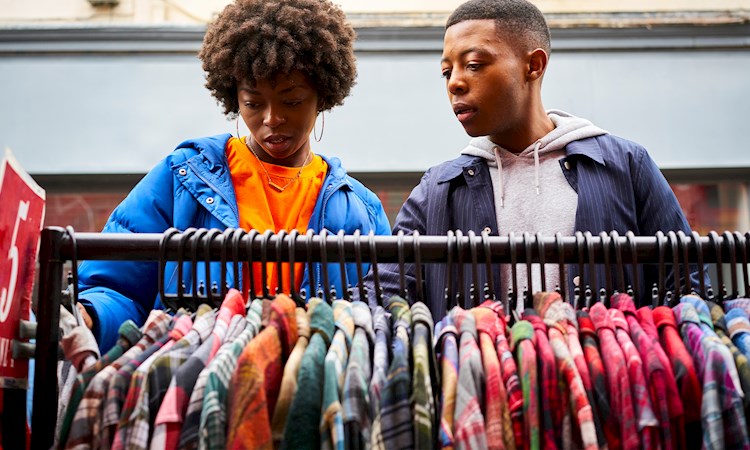 Two friends looking for clothes at a market