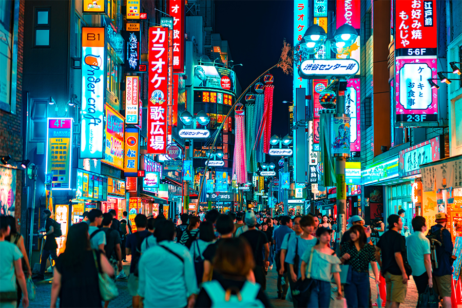 Busy city scene with neon signs and people walking