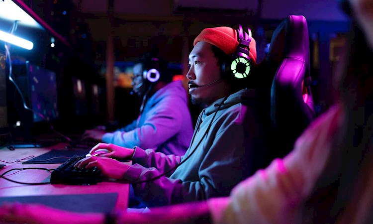 A row of online gamers in the purple hue of a screen