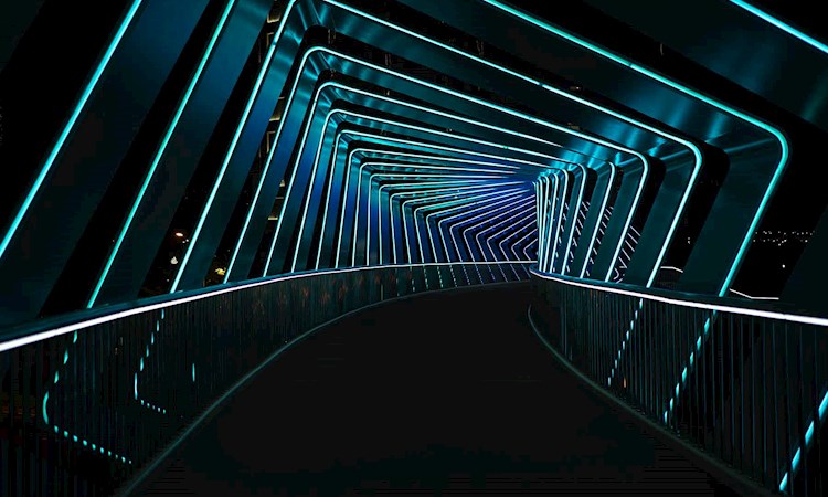 Corridor curving off into background with blue neon lights 