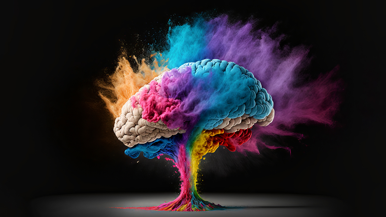 Colourful brain on a black background with coloured powder coming off it