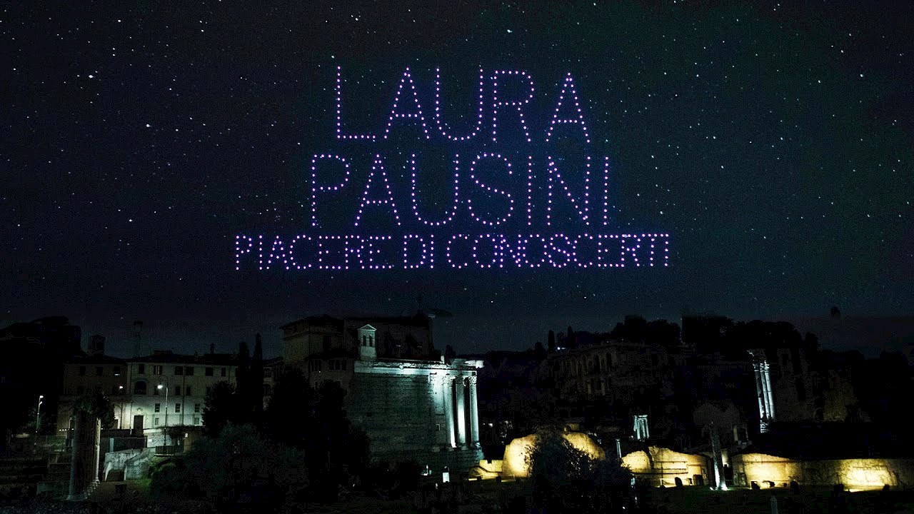 Rome's night sky with the words Laura Pausini Placere di Conoscerti written in the sky by purple drones