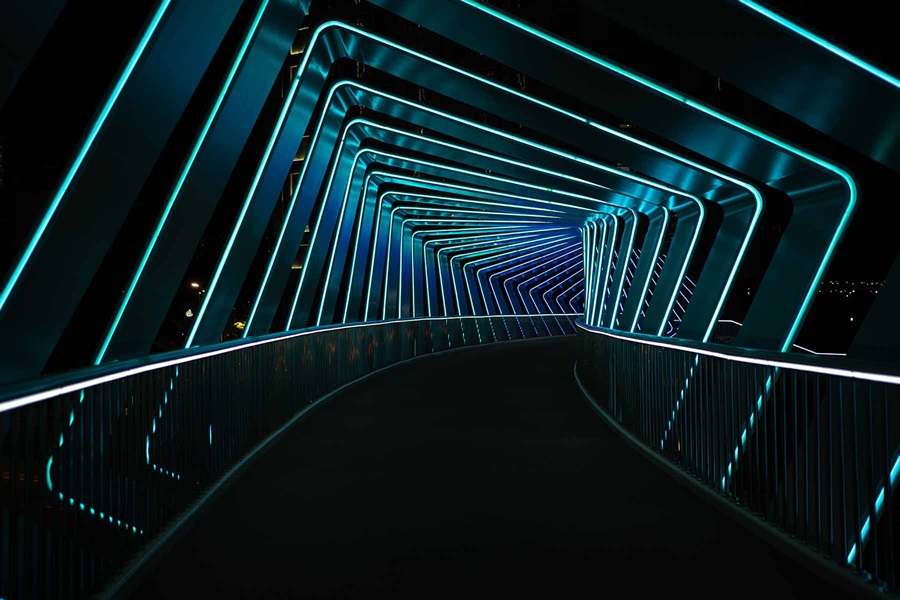 Corridor curving off into background with blue neon lights 
